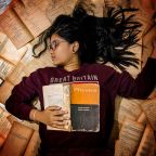 Exams. Girl lying on a pile of books.